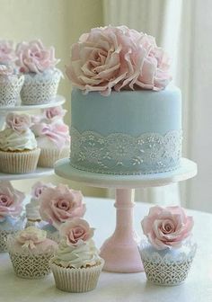 there are many cupcakes with pink flowers on the top and blue frosting