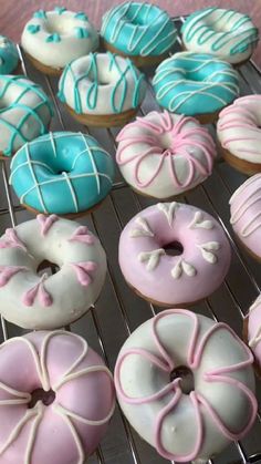 there are many donuts that are on the cooling rack and one is pink, blue and white