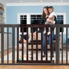 a man and woman standing behind a baby gate