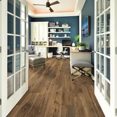 an office with wood flooring and blue walls is pictured in this image taken from the hallway