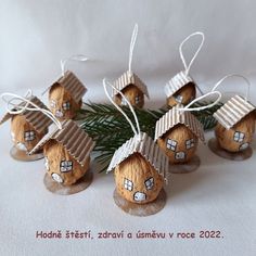 six small wooden houses with windows on them sitting next to a pine branch and white background