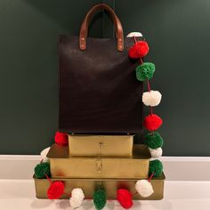 three suitcases stacked on top of each other with pom - poms attached to them