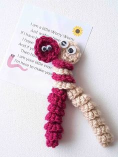 a crocheted keychain with googly eyes and a card attached to it