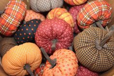 several pumpkins are in a basket with plaid fabric on them and tied to the sides