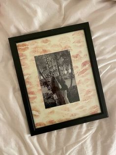 a black and white photo is hanging on a bed