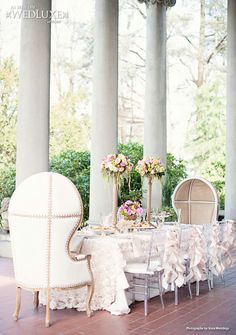 a table set up with chairs and flowers on it