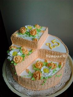 a three tiered cake with flowers on the top and bottom is sitting on a doily plate