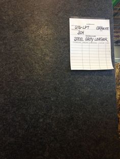 a note is posted on the side of a granite counter top in an office building