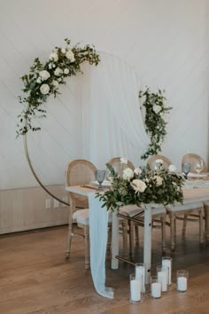 the table is set with candles, flowers and greenery for an elegant wedding reception