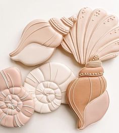 seashells and shells are arranged on a white surface, including one pink shell