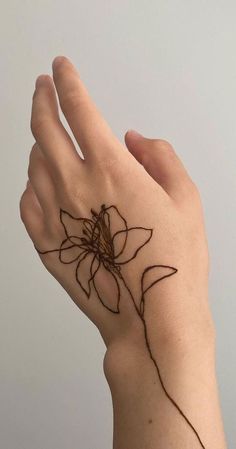 a woman's hand with a flower tattoo on it