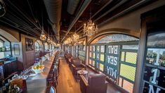 an empty restaurant with lots of tables and chairs in front of the windows that overlook the city