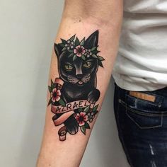 a woman's arm with a black cat and flower crown tattoo on her left arm