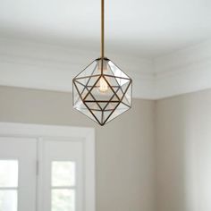 a light fixture hanging from the ceiling in a room with white walls and wooden floors