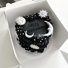 a black and white cake in a box with the words happy anniversary written on it