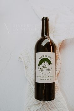 a bottle of wine sitting on top of a white blanket