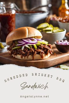 shredded brisket bbq sandwich on a cutting board with pickles and coleslaw