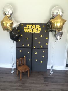 a star wars themed party with balloons and a chair in front of the door,