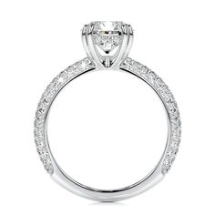 a white gold engagement ring with diamonds on the band and an oval shaped center stone