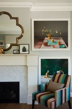 a living room filled with furniture and a fire place under a painting on the wall