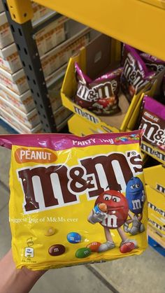 a person holding up a bag of m & m's