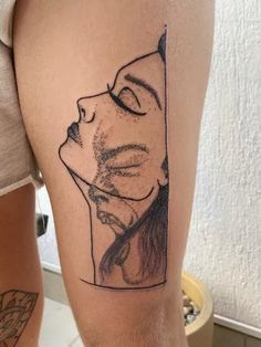 a woman's leg with a tattoo on it that has an image of her face