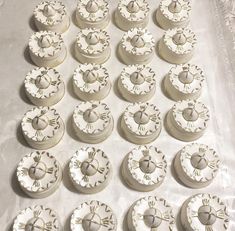 a table topped with lots of white cupcakes covered in frosting