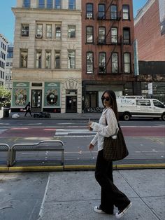 a woman walking down the street in front of buildings