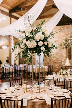 an elegant centerpiece with white flowers and greenery