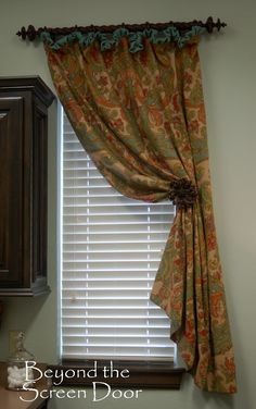 a kitchen window with a curtain hanging from it's side and the words beyond the screen door