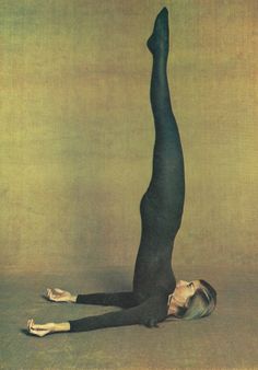 a woman is doing a yoga pose on the floor with her legs up in the air