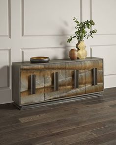 a sideboard with two vases on top of it