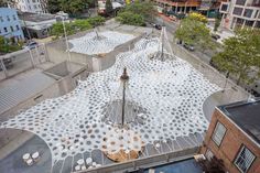 an aerial view of the roof of a building with white dots on it and trees in the background