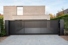 a modern house with an iron gate in the front yard