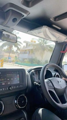 a man driving a car with his hands on the steering wheel and other vehicles in the background