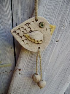 a wooden bird hanging from a rope on the side of a building