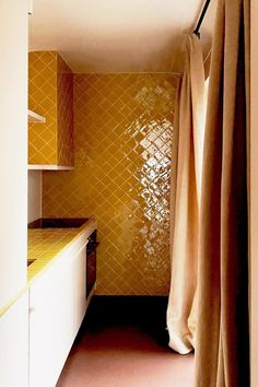 a small kitchen with yellow tile on the walls