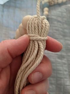 a person holding a rope in their hand and knoting it with the end string