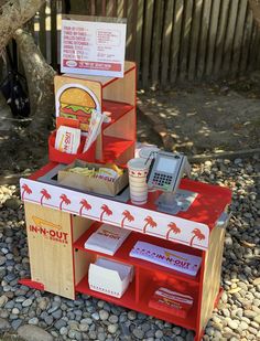 a toy food stand with a phone and other items on it