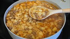 a pot filled with pasta and meat on top of a stove