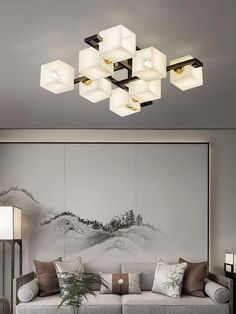 a living room filled with lots of furniture and lighting fixture mounted on the wall above it