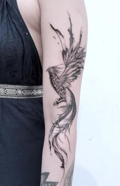 a woman's arm with a bird tattoo on it