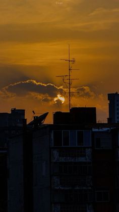 the sun is setting behind some buildings