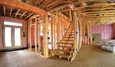 the inside of a house being built with wooden framing and wood stairs leading up to the second floor