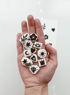 a hand holding several different types of buttons in it's palm, with hearts and flowers on them