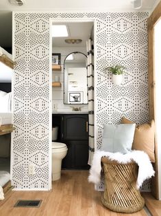 the bathroom is decorated in black and white with an interesting wallpaper pattern on the walls