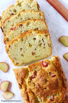 sliced loaf of bread sitting on top of paper next to an apple and cinnamon stick