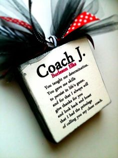 a sign that says coach j hanging on a doorknob with red and black ribbon