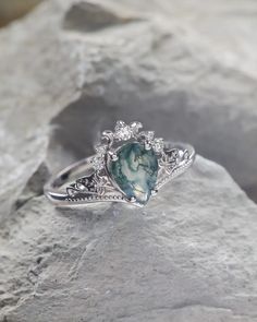 a close up of a ring with a stone in the middle on top of some rocks