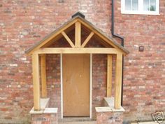 a small wooden structure sitting in front of a brick building